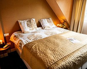 Elegante slaapkamer met gouden tinten in Vakantiehuis in Fluitenberg, Zuidwest Drenthe.