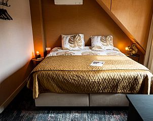 Ruime slaapkamer in Vakantiehuisje in Fluitenberg, Drenthe, met luxe beddengoed en warme verlichting voor een ontspannen verblijf.