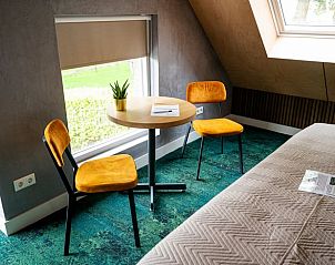 Gezellige zithoek in Huisje in Fluitenberg, vakantieaccommodatie in Drenthe met uitzicht op de groene omgeving.