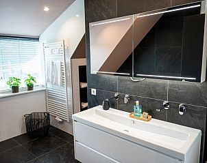 Moderne badkamer in Vakantiehuis in Fluitenberg, Zuidwest Drenthe met stijlvolle wastafel en grote spiegel.