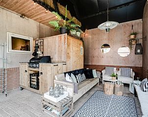 Overdekte lounge bij Huisje in Fluitenberg met comfortabele zitplaatsen in Drenthe.