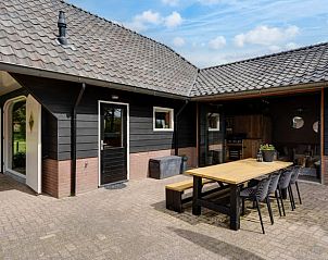 Buitenterras met eettafel bij Huisje in Fluitenberg, perfect voor zomerse avonden in Drenthe.
