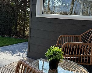 Cozy terrace at Holiday Home in Doldersum, Drenthe with comfortable chairs and plants.