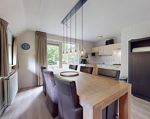 Gemtlicher Essbereich im Ferienhaus Borre Bos in Diever mit moderner Kche und Blick auf die grne Umgebung von Sdwest-Drenthe.