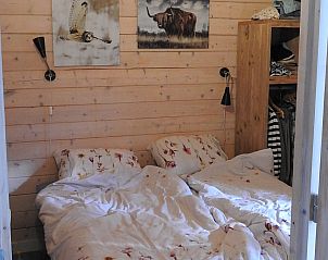 Gezellige slaapkamer in Vrijstaande woning in Ruinen, Zuidwest Drenthe, met houten wanden en comfortabele bedden voor een rustgevend verblijf.