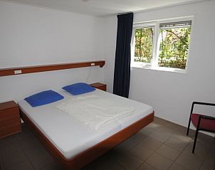 Slaapkamer in Vakantiehuis in Ruinen, Zuidwest Drenthe, met comfortabel bed en uitzicht op de groene omgeving.