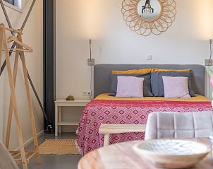 Cozy bedroom in Huisje in Ruinen, a vacation home in Southwest Drenthe, with colorful decorations and comfortable furnishings.