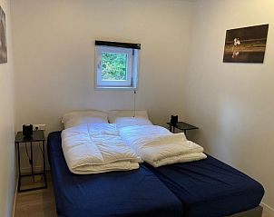 Comfortabele slaapkamer in Vakantiehuis Just Nature, Ruinen, Drenthe, met rustgevend uitzicht op de natuur.