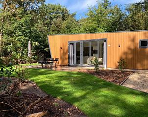 Entree van Vakantiehuis Just Nature in Ruinen, Drenthe, met een uitnodigend terras en groene omgeving.