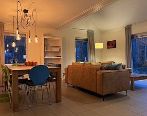 Gemtliches Wohnzimmer im Ferienhaus in Ruinen, Sdwest-Drenthe, mit bequemer Sitzecke und stimmungsvoller Beleuchtung.