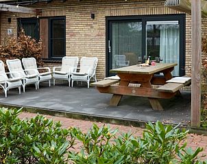 Buitenruimte met hot tub omgeven door groen bij Vakantiehuisje in Dwingeloo, Drenthe.