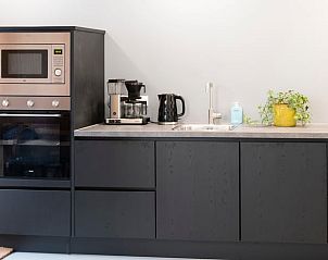 Gezellige eetkamer in Vakantiehuisje in Dwingeloo, Zuidwest Drenthe, met houten tafel en sfeerverlichting.