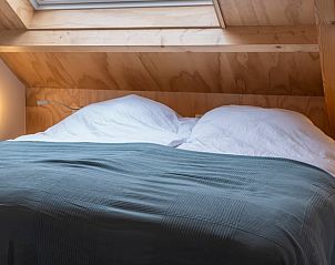 Knusse slaapkamer in Vakantiehuisje in Dwingeloo, Drenthe, onder een houten dak.