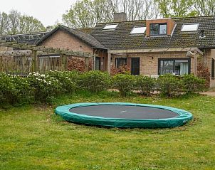 Tuin met trampoline bij Vakantiehuisje in Dwingeloo, Drenthe, ideaal voor kinderen om te spelen.