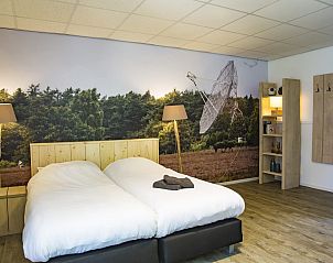 Sfeervolle slaapkamer in Groepsaccommodatie de Komeet, vakantiehuis in Dwingeloo, Zuidwest Drenthe, met bosrijk uitzicht.