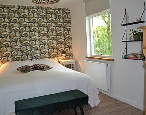 Sfeervolle slaapkamer in Vakantiehuis in Dwingeloo, Drenthe met uitzicht op de natuur.