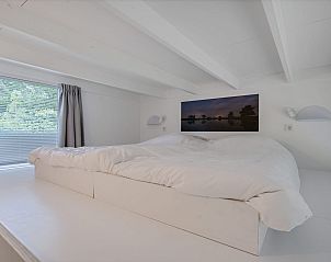 Moderne loft slaapkamer in Tiny Houselodge Eris, glamping lodge in Dwingeloo, Drenthe, met comfortabel bed.