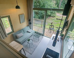 Lichte woonkamer in Tiny Houselodge Eris, vakantiehuis in Dwingeloo, Drenthe, met uitzicht op het terras.