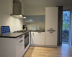 Gezellige woonkamer in DG1823 vakantiehuis, Dwingeloo, Drenthe, met uitzicht op de groene omgeving.