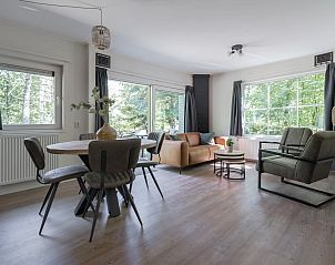 Gezellige woonkamer van Bungalow Jupiter in Dwingeloo, Zuidwest Drenthe, met uitzicht op de groene natuur.