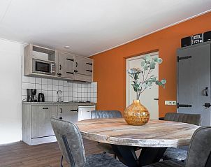 Gezellige binnenruimte van Bungalow Jupiter in Dwingeloo, Zuidwest Drenthe met een rustieke keuken en sfeervolle eetruimte.