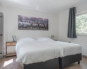 Sfeervolle slaapkamer in Bungalow Jupiter, vakantiehuis in Dwingeloo, Drenthe, met comfortabel tweepersoonsbed en landelijke decoratie.