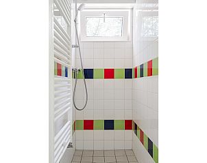 Moderne douche in Bungalow Jupiter, een vakantiehuis in Dwingeloo, Zuidwest Drenthe, met kleurrijke tegels en natuurlijke lichtinval.