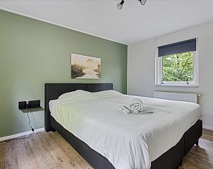 Hoofdslaapkamer van Bungalow Pluto in Dwingeloo, Drenthe. Vakantiehuis met uitzicht op de natuur.