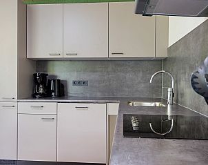 Moderne Kche im Bungalow Orion, Dwingeloo, Sdwest-Drenthe, ausgestattet mit modernen Gerten und glatter Oberflche.