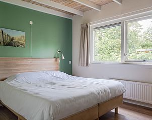 Slaapkamer in Bungalow Saturnus, Dwingeloo, Zuidwest Drenthe, met uitzicht op de natuur voor een rustgevend verblijf in een vakantiehuis.