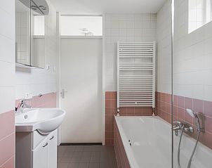Moderne badkamer in Bungalow Zon, vakantiehuis in Dwingeloo, Zuidwest Drenthe met bad en wastafel voor ultiem comfort.