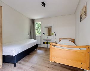 Ruime slaapkamer met twee bedden in Aangepaste bungalow Sirius, vakantiehuis in Drenthe.