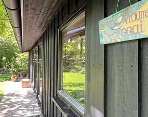 Detail van de buitenkant van Huisje in Dwingeloo, met naamplaatje en groene omgeving.