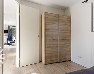 Zonnig terras van DG1576 vakantiehuis in Dwingeloo, Zuidwest Drenthe, met groene parasol.