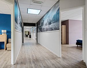 Lange gang in Groepsaccommodatie de Komeet, Dwingeloo, met toegang tot diverse kamers en faciliteiten.