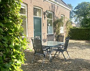Genieen Sie den schnen Auenbereich des Ferienhauses DG2051 in Ruinerwold, Sdwest-Drenthe, mit einer gemtlichen Terrasse und grner Umgebung.
