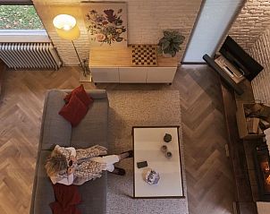 Gezellige woonkamer in Vakantiehuisje in Zorgvlied, Zuidwest Drenthe, met comfortabele zithoek en sfeervolle open haard.