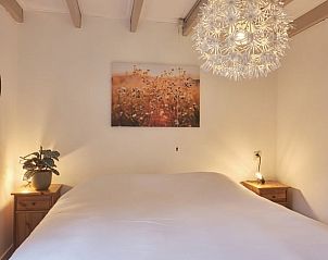 Gezellige slaapkamer in Vakantiehuisje in Zorgvlied, Zuidwest Drenthe, met sfeervolle verlichting en kunst aan de muur.