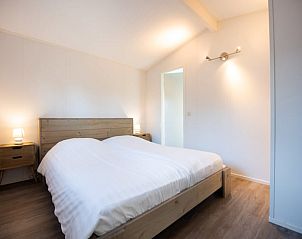 Gezellige slaapkamer in Huisje in Zorgvlied, Zuidwest Drenthe. Comfortabel vakantiehuis met houten interieur en sfeervolle verlichting.