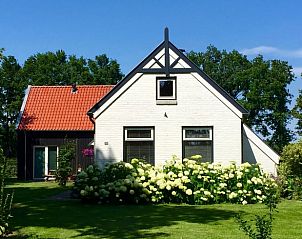 Voorzijde van Vakantiehuis in Wapse, Zuidwest Drenthe, met kleurrijke bloemen.