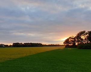 Zonsondergang over groene velden bij Vakantiehuisje in Wapse, Zuidwest Drenthe.