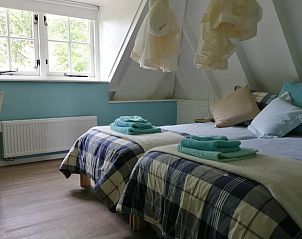 Slaapkamer met uitzicht op natuur in Vakantiehuisje in Wapse, rustgevend verblijf in Drenthe.