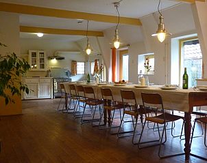 Gezellige eetruimte in Vakantiehuisje in Wapse, Zuidwest Drenthe, met lange tafel en sfeervolle verlichting, perfect voor familiebijeenkomsten.