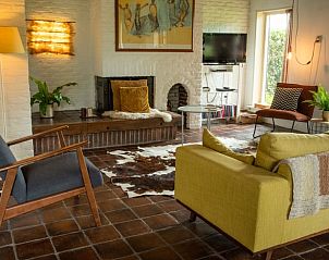 Gezellige woonkamer in Vakantiehuisje in Wapse, Zuidwest Drenthe. Comfortabele zithoek met open haard en natuurlijk licht in Drenthe.