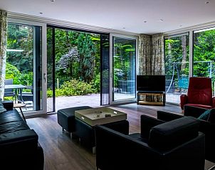 Gemtliches Wohnzimmer im Ferienhaus in Wateren, Drenthe, mit Blick auf den grnen Garten und die Terrasse, ideal fr einen entspannten Aufenthalt.