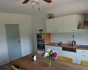 Gemtliche Essecke im Ferienhaus in Tiendeveen, Drenthe mit Blumen und modernen Kchengerten.