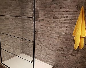 Luxusdusche im Ferienhaus in Tiendeveen, Drenthe mit Steinfliesen und Glaswand.