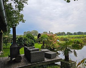 Unieke houten sauna bij Huisje in Dieverbrug, Zuidwest Drenthe, omgeven door bloemen en natuur.
