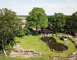 Uitzicht vanaf het terras van Huisje in Dieverbrug, Zuidwest Drenthe, met comfortabele stoelen en een serene vijver.