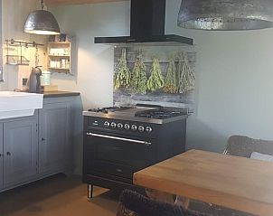 Comfortabele woonkamer in Huisje in Dieverbrug, Zuidwest Drenthe, met kleurrijke decoratie en knusse bank.